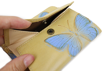 コンパクトな蝶の型押し二つ折り財布（牛革/日本製）小銭入れ部分の開閉はホック式です。