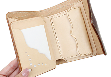 ミドルサイズの二つ折り財布（牛革/日本製）下段の収納部分のみハト目で革を抜いている為、収納しているカードが見える仕様です。
